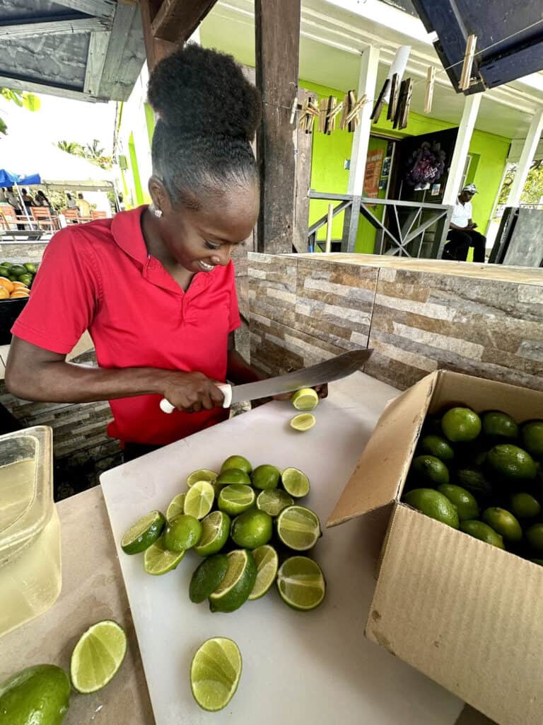 Woman cutting limes in an outdoor kitchen.