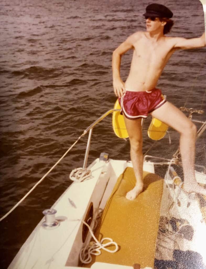 Captain Paul on the deck of a sailboat in short shorts, at age 17.