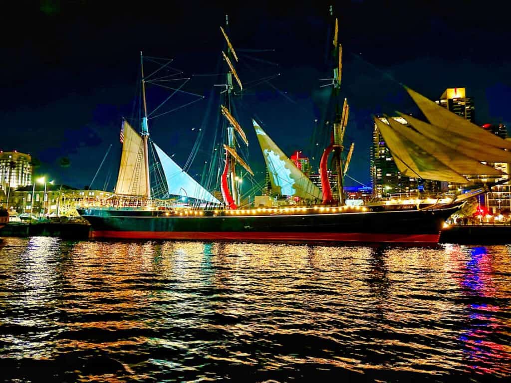 The Star of India at night, with lights reflecting off the water of the San Diego Bay