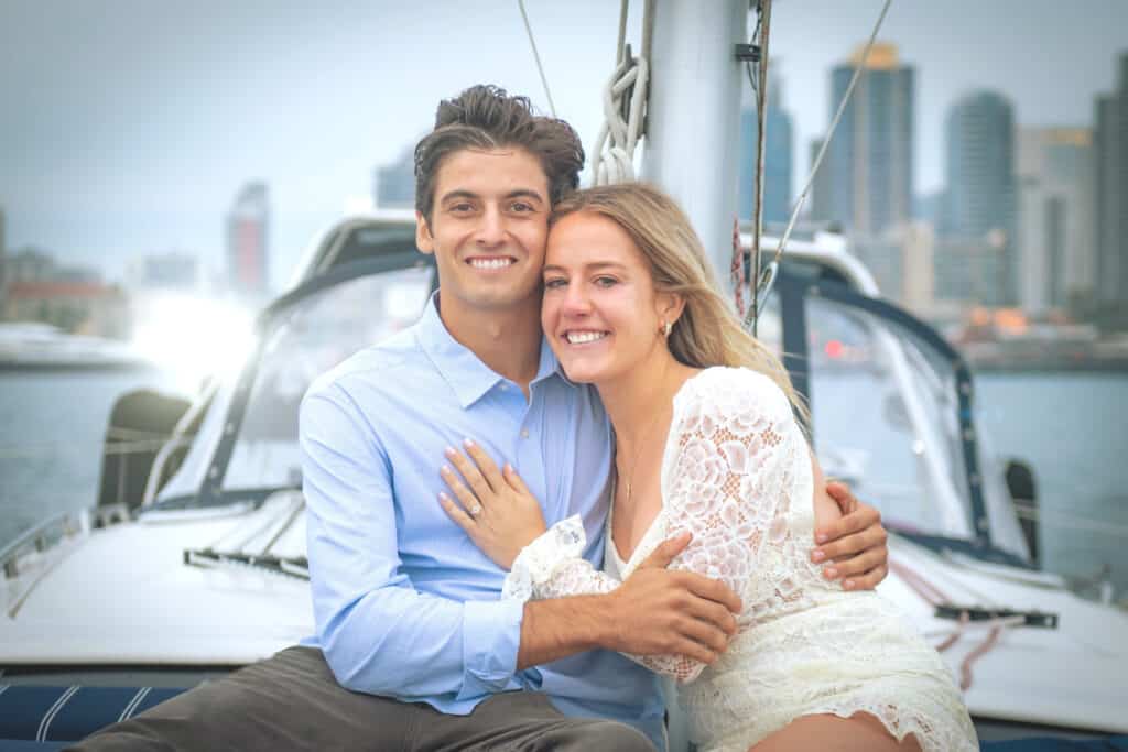 Newly-engaged couple embracing and posing for the camera on the Riviera sailboat.