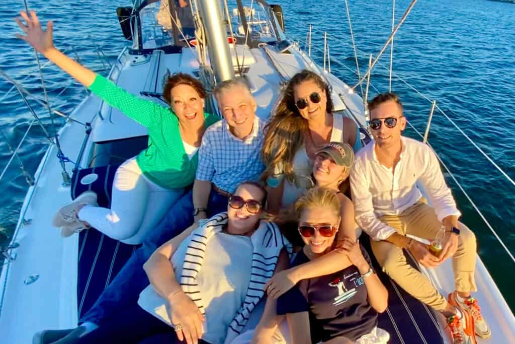 Group of people posing for a photo on the deck of a sailboat