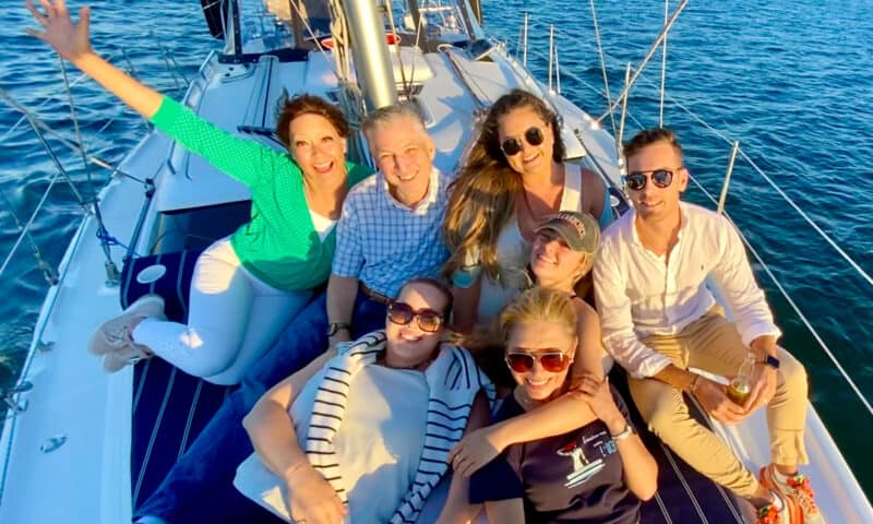 Group of people posing for a photo on the deck of a sailboat