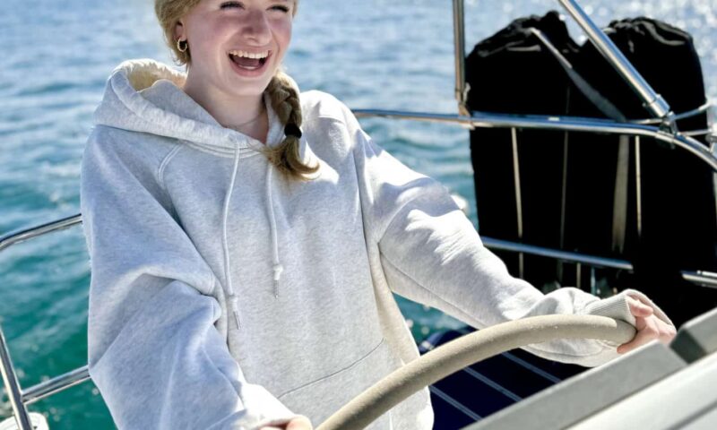 Teenage girl smiles as she sails on the SV Riviera