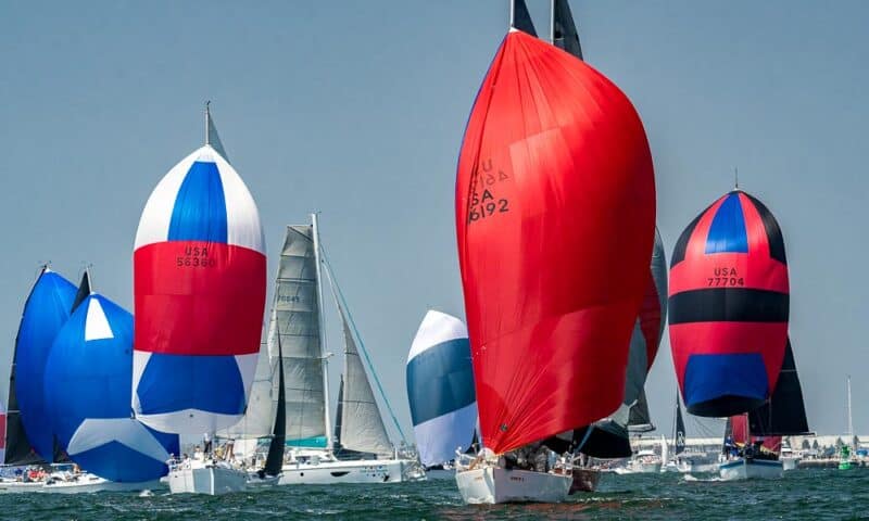 Colorful sail boats cruise along the harbor.