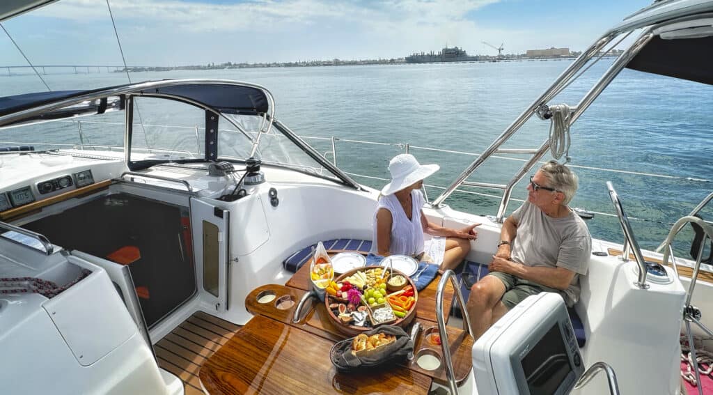 A couple sits aboard the SV Riviera, enjoying drinks, appetizers, and the view. 