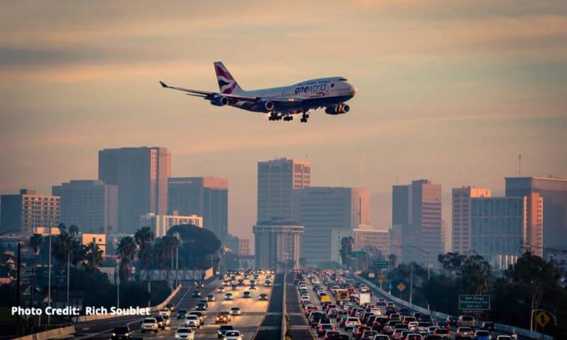 An airplane coming in over a busy highway as it prepares to land in San Diego.