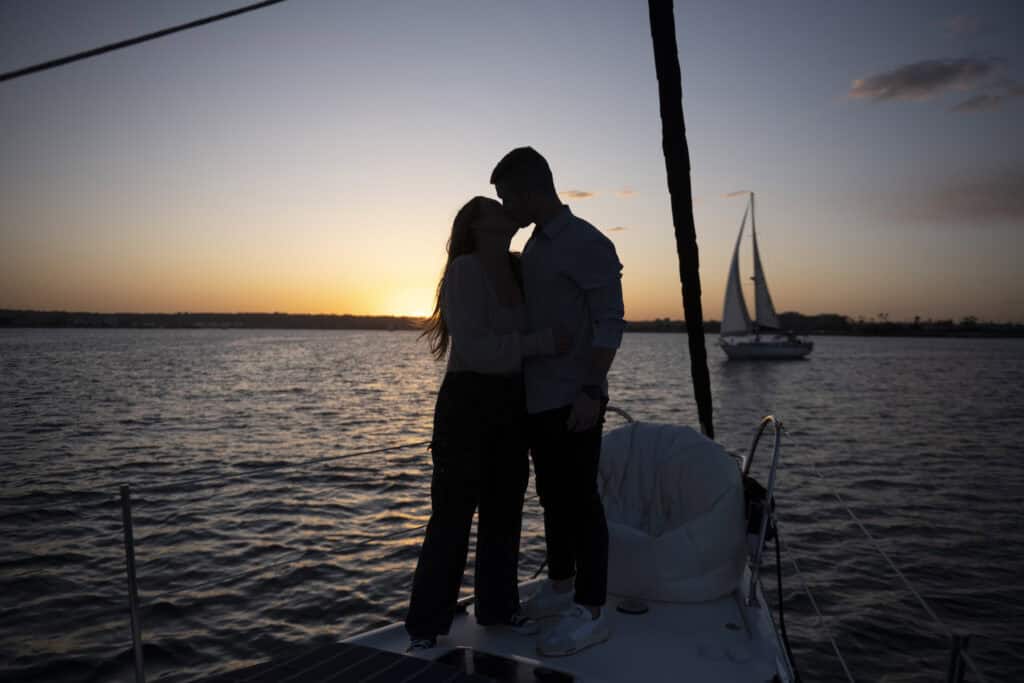 A couple embrace on the deck of the Riviera during a sunset sail.