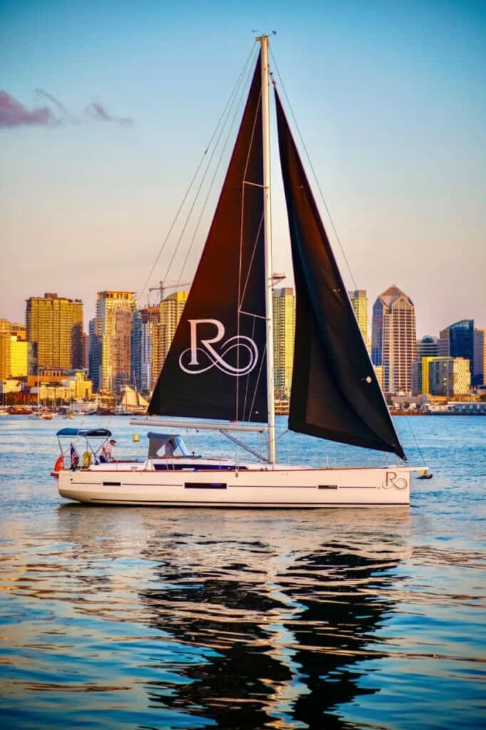 Riviera sailboat on the San Diego bay at sunset with the downtown skyline in the background.