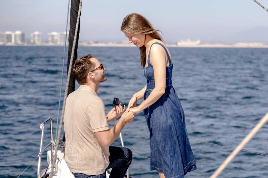 A man proposing to his girlfriend on the deck of the Riviera sailboat.