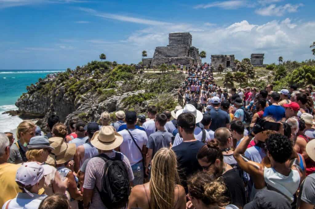 A crowd waiting in line to see ancient ruins in a tropical location