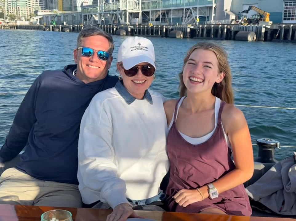 A couple and their daughter smiling about the Riviera sailboat on the San Diego Bay.