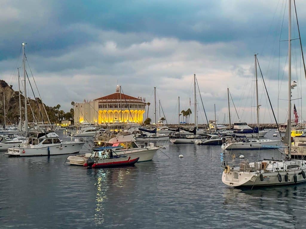 Avalon harbor and casino at dusk, with moored boats.