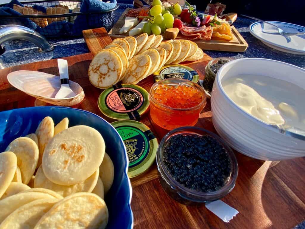 Assorted appetizers on a yacht table with crackers, spreads, and condiments.