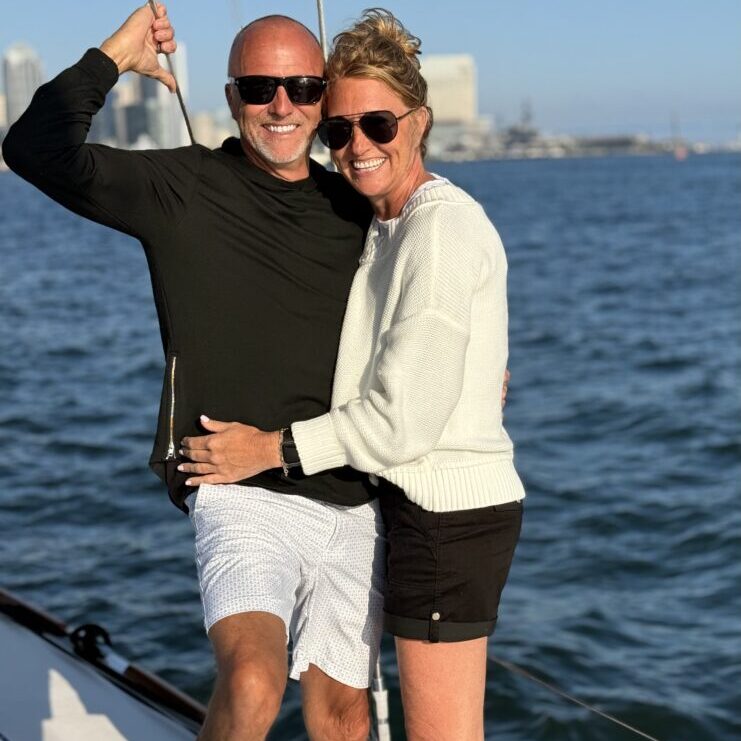 Couple embracing on the deck of the Riviera sailboat.
