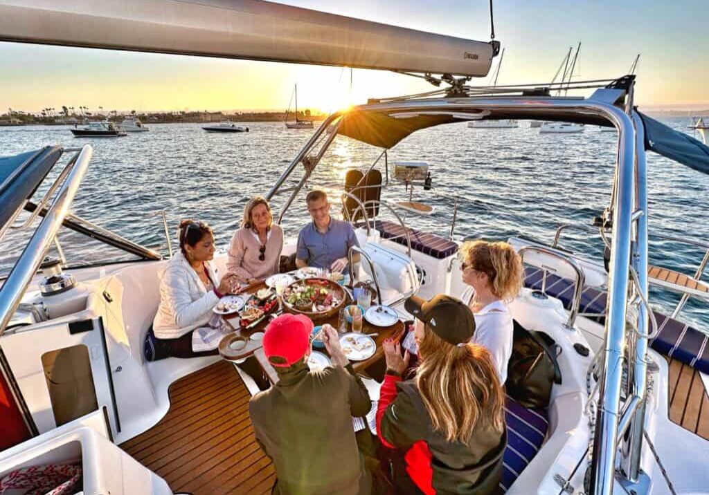 Group of people enjoying a meal onboard the Riviera sailboat in the San Diego Bay