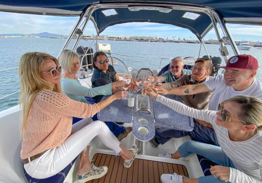 A group of friends toast wine and enjoy a beautiful day sailing on San Diego Bay.